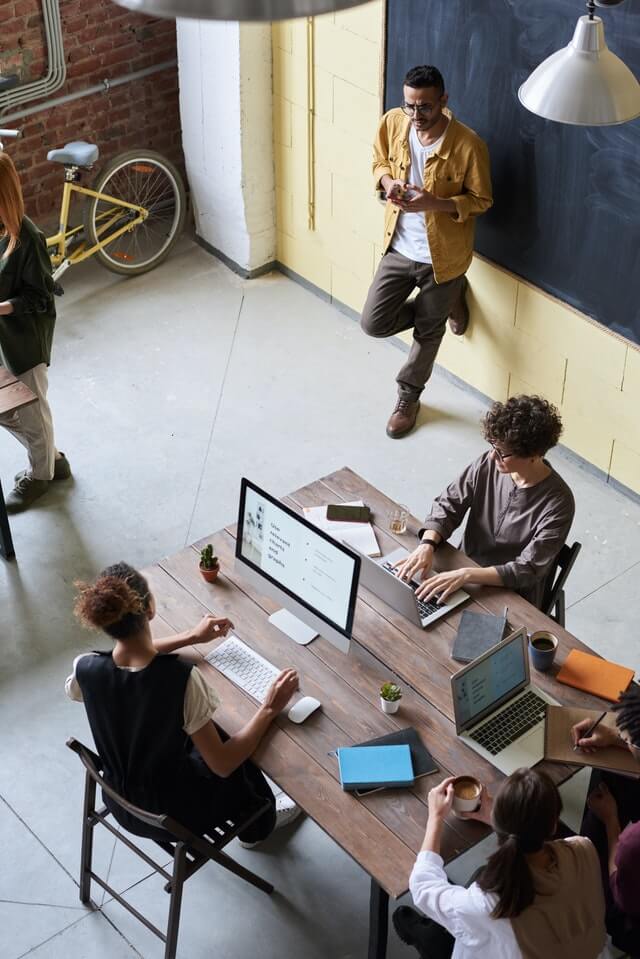 An enterprise BPO team working at a shared office table representing a strategic managed pods offshore staffing Philippines setup