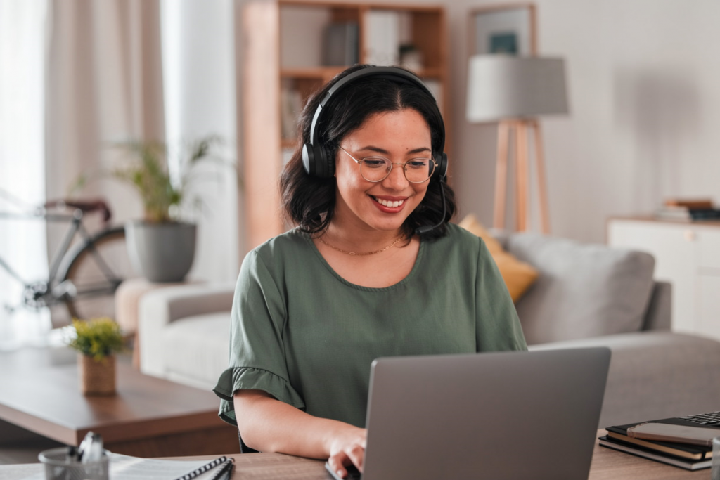 Professional Filipino virtual assistant providing remote administrative support using a laptop and headset in a modern home office.